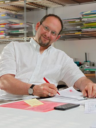 Hendrik Nitschke am Schreibtisch bei der Planprüfung